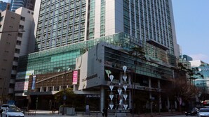 A tall hotel with a modern glass facade, located at a city intersection. - W Residence Hotel Centum City (Busan)