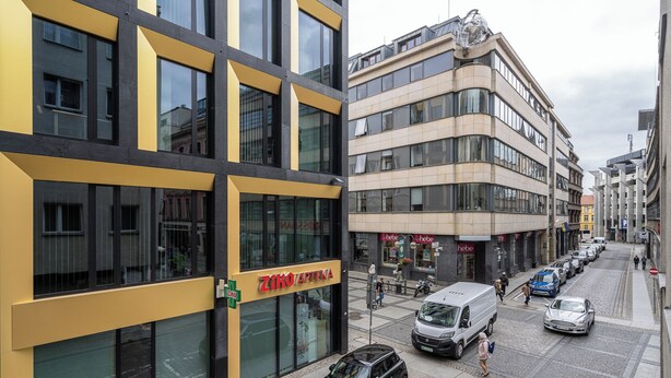 Un bâtiment moderne doté de grandes fenêtres et d’une façade jaune.