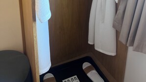A wooden wardrobe with a hanging robe and a towel. - 1 Regent Square (Rye)