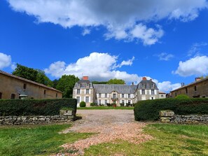 A large, historic building with a symmetrical facade, a gravel driveway, and well-maintained hedges. - Country House in the Heart of the Wooded Park of a Castle (La Chapelle-Bâton)