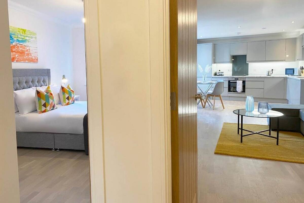 Une chambre d’hôtel moderne équipée d’un lit, d’un petit coin repas et d’une kitchenette.