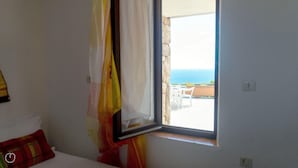 A room with a window overlooking a patio with a view of the sea. - La Casa di Margherita (Budoni)