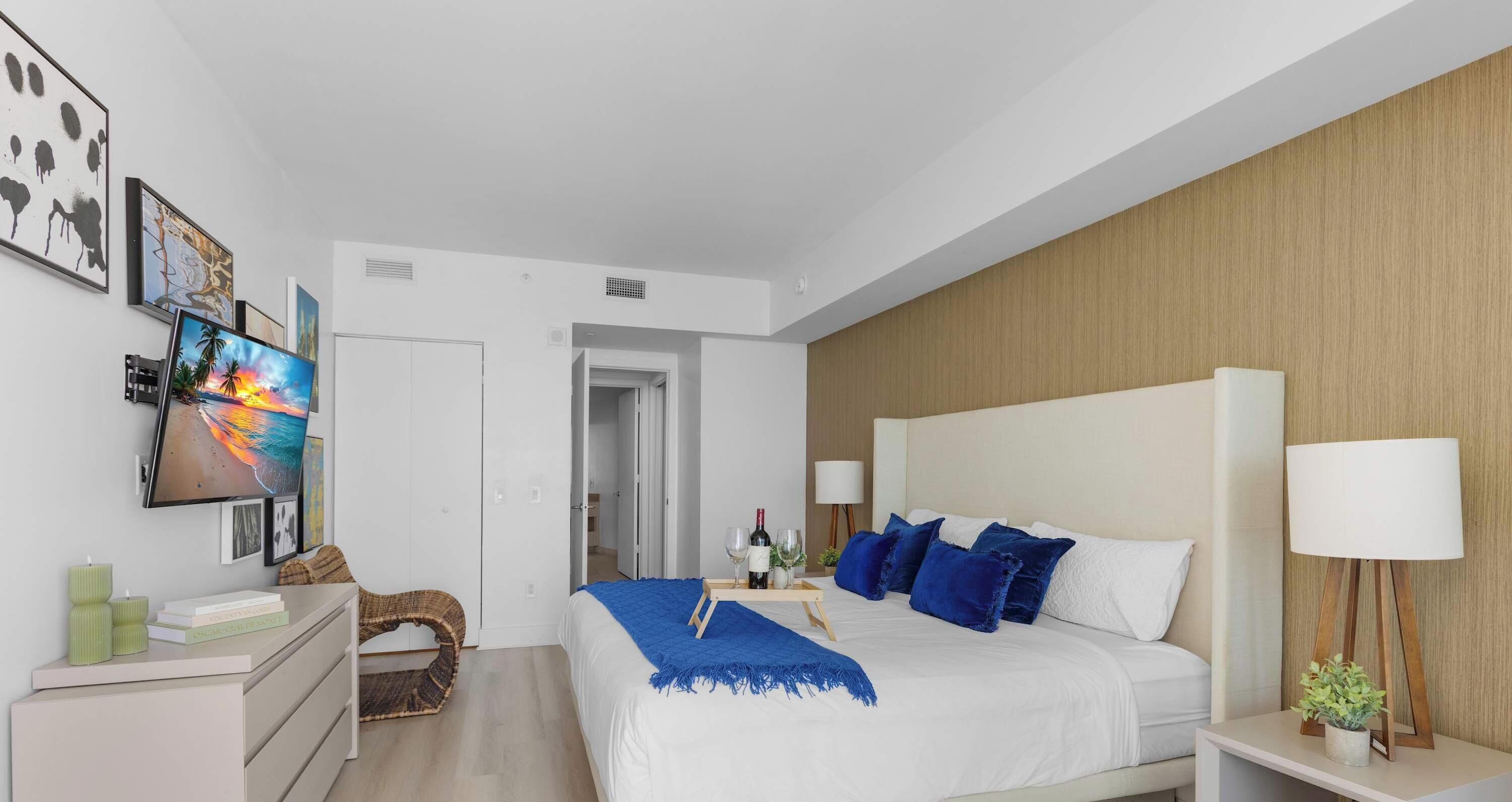 A modern bedroom with a bed, bedside tables, a desk, and a chair.