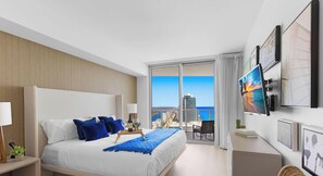 Una moderna camera d'albergo con un letto grande, un balcone con vista sulla città e opere d'arte alle pareti.