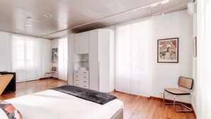 Un dormitorio moderno con cama, armario y una silla.