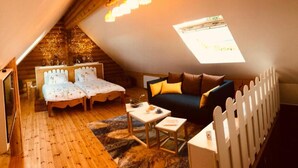 A cozy attic bedroom with two single beds, a sofa, a small table, and a white picket fence. - Neizhig Koad Petit Nid en Bois (Péaule)