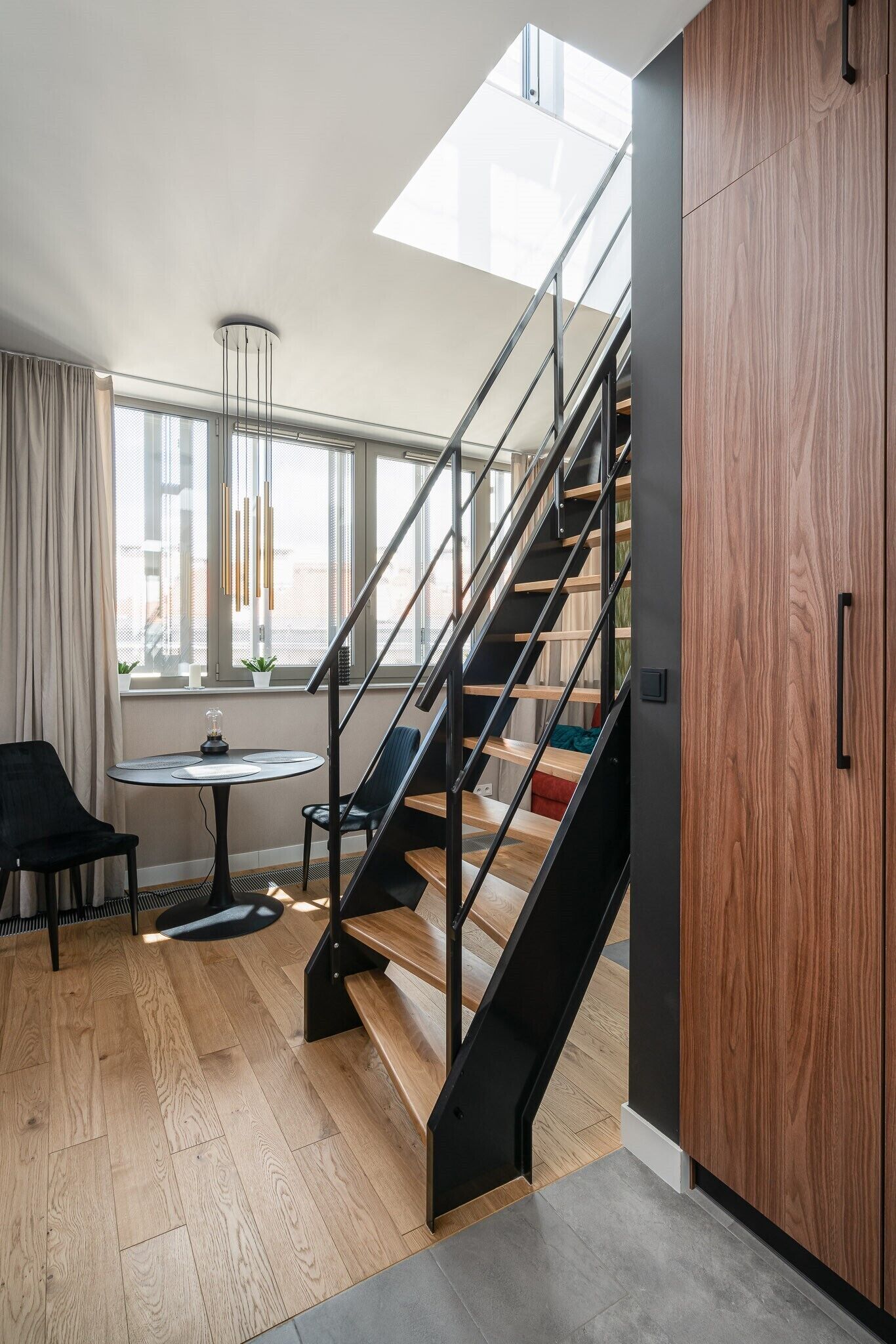 A modern interior with a staircase, a round table, and a chair.