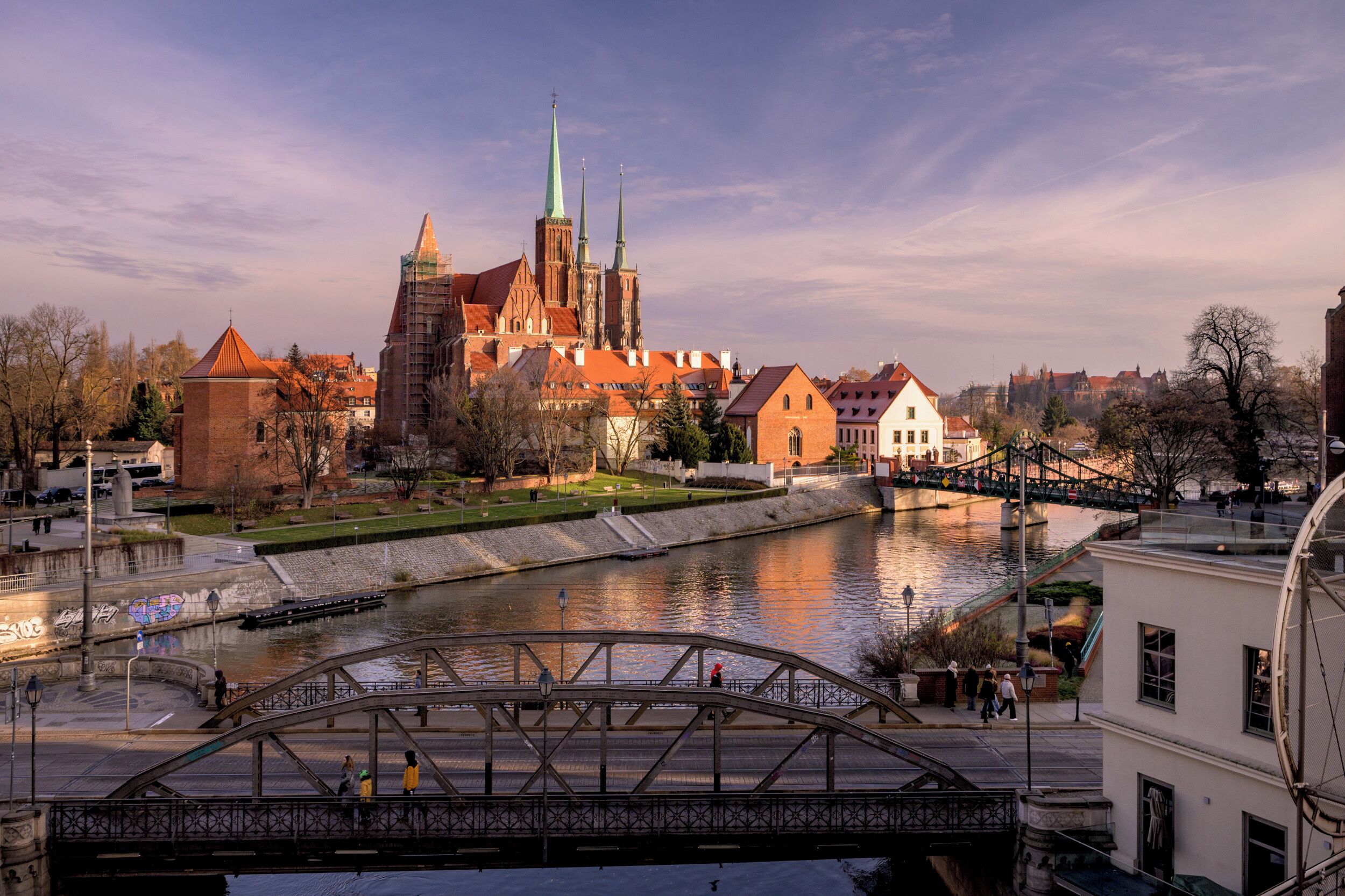 Une église historique dotée d’un clocher imposant et d’un pont enjambant une rivière.