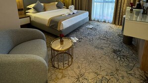 Une chambre d’hôtel comprenant un lit, un canapé, une petite table et une salle de bain.
