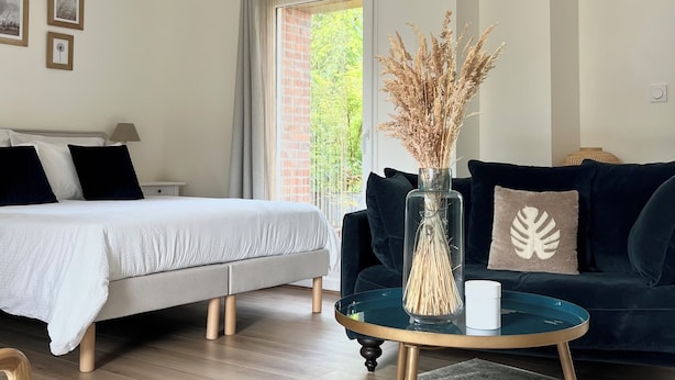 A modern bedroom with a bed, bedside table, and a window with curtains.