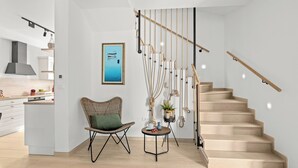 A modern interior with a staircase, a dining area, and a kitchen. - Casa Dika Pool & Lounge (Marcana)