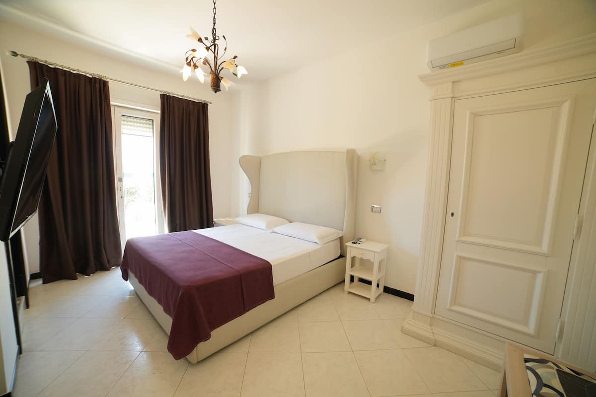 A bedroom with a bed, a nightstand, a wardrobe, and a ceiling fan.