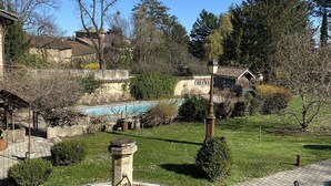 A courtyard with a fountain, a swimming pool, and surrounding greenery. - Les Jardins de la Tour (Chatillon-sur-Chalaronne)
