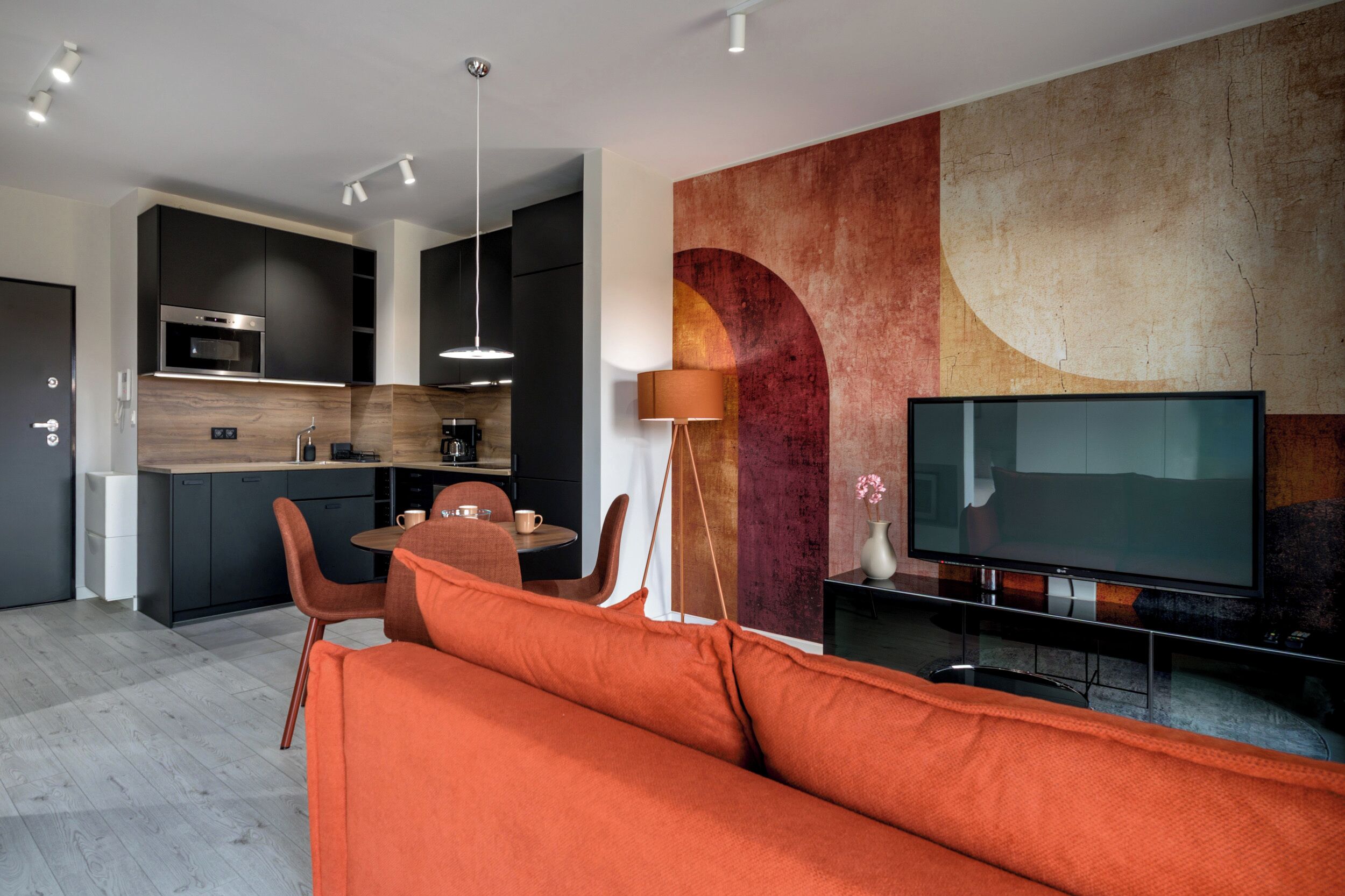 A modern living space with a kitchen, dining area, and a TV.