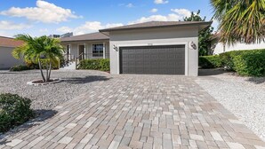 Una propiedad residencial con entrada pavimentada, garaje y césped bien cuidado.