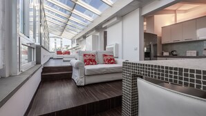 A modern kitchen with a skylight, a dining area with white furniture, and a view of the city through large windows. - Italianway Comfort - Torino 57 B (Milan)