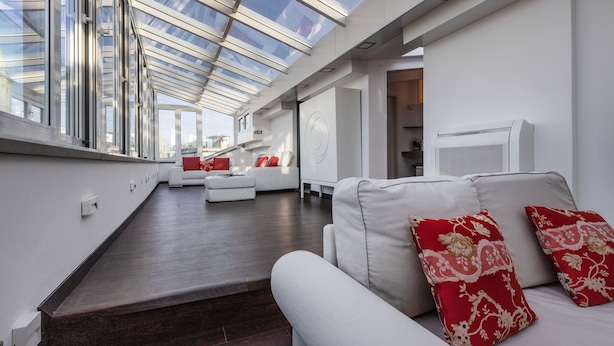 A modern living room with a skylight, white sofas, and red patterned cushions. - Italianway Comfort - Torino 57 B (Milan)