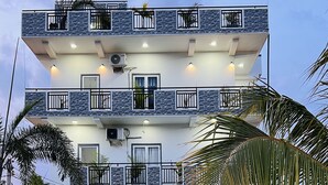 A modern two-story building with a swimming pool, outdoor seating, and a landscaped garden. - Blue Diamond Resort (Trincomalee)