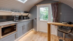 A compact kitchen with a built-in oven, a sink, and a window above the counter. - Long Ashes - Pip (Skipton)