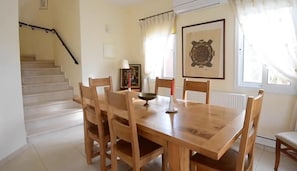 A dining area with a wooden table and chairs, a staircase, a radiator, and a framed picture on the wall. - Fab Sea&mountain View Villa Close to the Beach (Gialia)