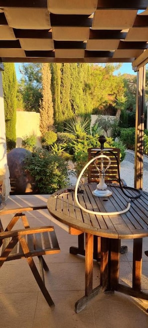 A wooden outdoor table with a metal base, surrounded by a pergola structure. - Fab Sea&mountain View Villa Close to the Beach (Gialia)