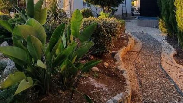 Un edificio de dos pisos con un jardín delantero.