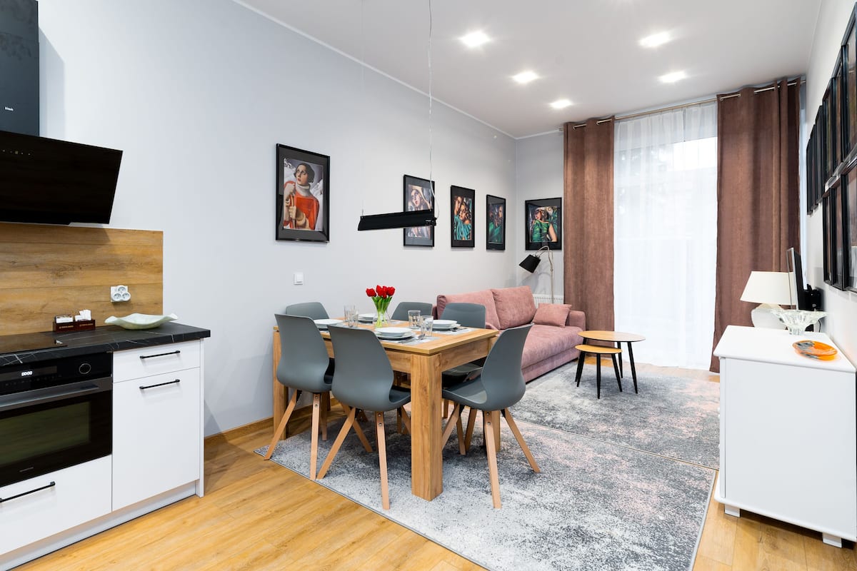 A modern apartment with a kitchen, dining area, and living room.