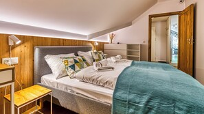 A bedroom with a bed, bedside table, and a wardrobe. - Apartamenty Sun & Snow Ostoja Parku Narodowego (Szklarska Poreba)