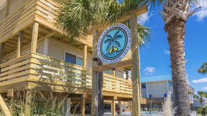 A wooden building with a sign indicating it is a condominium. - 2BR Beach Getaway w/ Pool walkable to The Hangout!  ~ Walk to beach in 3 minutes (Gulf Shores)