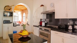 A modern kitchen with white cabinets, stainless steel appliances, and a central island with fruit. - Villa Roka : Magnifique Villa Avec Piscine, Dans un Endroit Calme et Reposant (Essaouira)