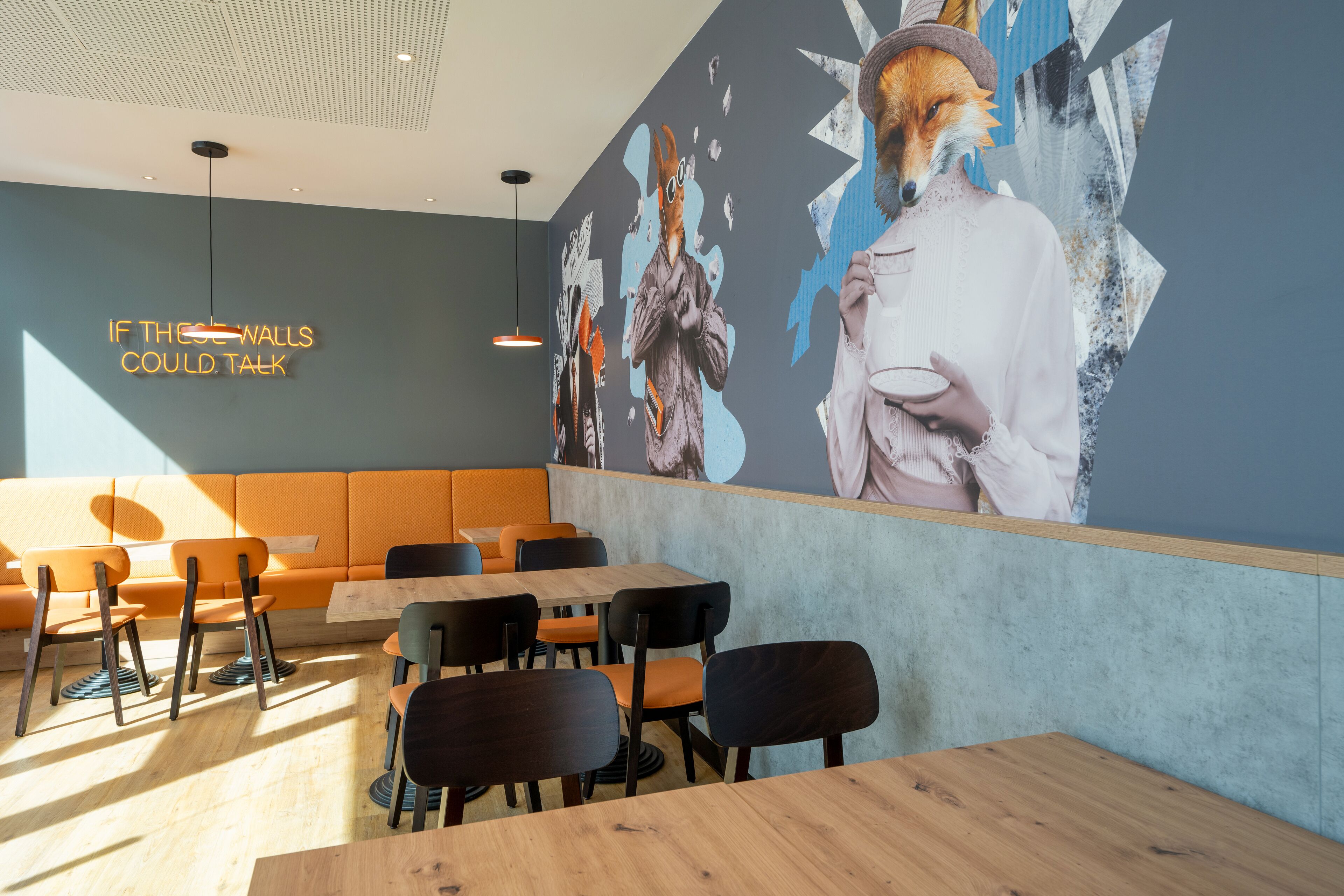 Un interior de restaurante moderno con un mural grande, zona de asientos y un letrero de neón.