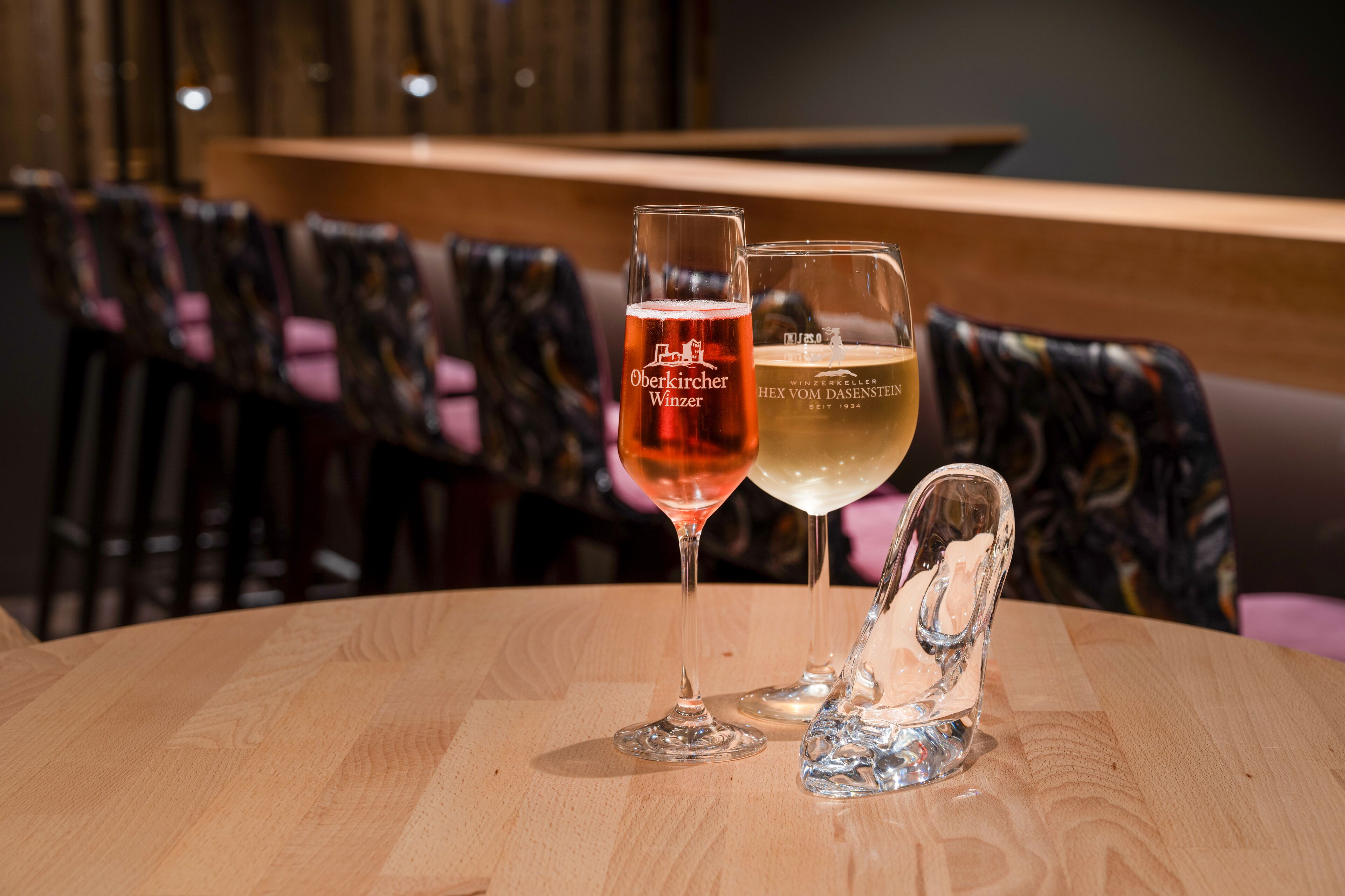 Twee biertjes op een ronde houten tafel, met een stoel op de achtergrond.