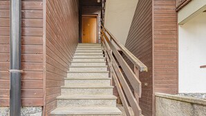 Una escala amb barana de fusta que condueix a una porta a dalt.
