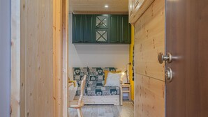 Habitació acollidora amb llit, una cadira i un armari de fusta.