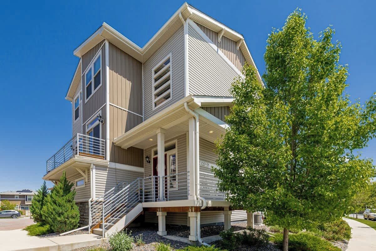 A two-story house with a balcony, a covered porch, and a staircase leading to the entrance.