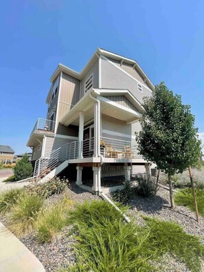 A multi-story house with a covered porch and a staircase leading to the upper levels.