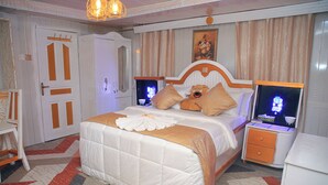 A bedroom with a large bed, two bedside tables, a wardrobe, and a mirror. - AFRIKANDO ROYAL CASTLE (Dar es Salaam)