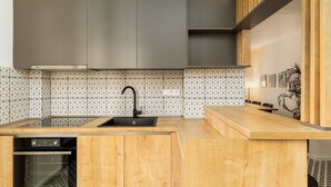 Eine moderne Küche mit Holdekor, einem eingebauten Ofen und einem schwarzen Wasserhahn.