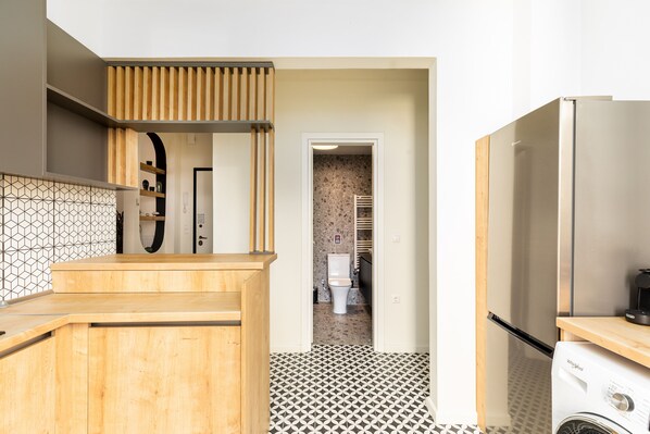 A modern kitchen with a wooden countertop, a built-in stove, and a refrigerator.