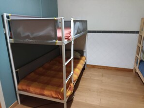 A bunk bed room with a blue wall and a tiled floor. - Bed In A 6-bed Dormitory Room 2 male And Female Mix Use (Sintra)