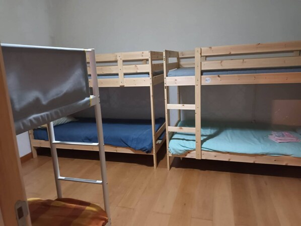 A room with three bunk beds, wooden flooring, and a metal ladder. - Bed In A 6-bed Dormitory Room 2 male And Female Mix Use (Sintra)