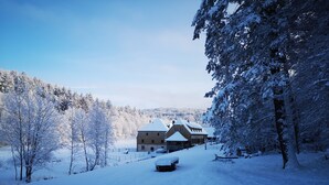 A snow-covered landscape with a large building, possibly a lodge, surrounded by trees. - Maison d'hôtes de charme - Ancien moulin en pleine nature - La Paulusmühle (Soucht)