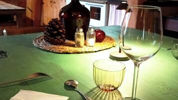 A table set with a knife, spoon, glass, and a bottle.