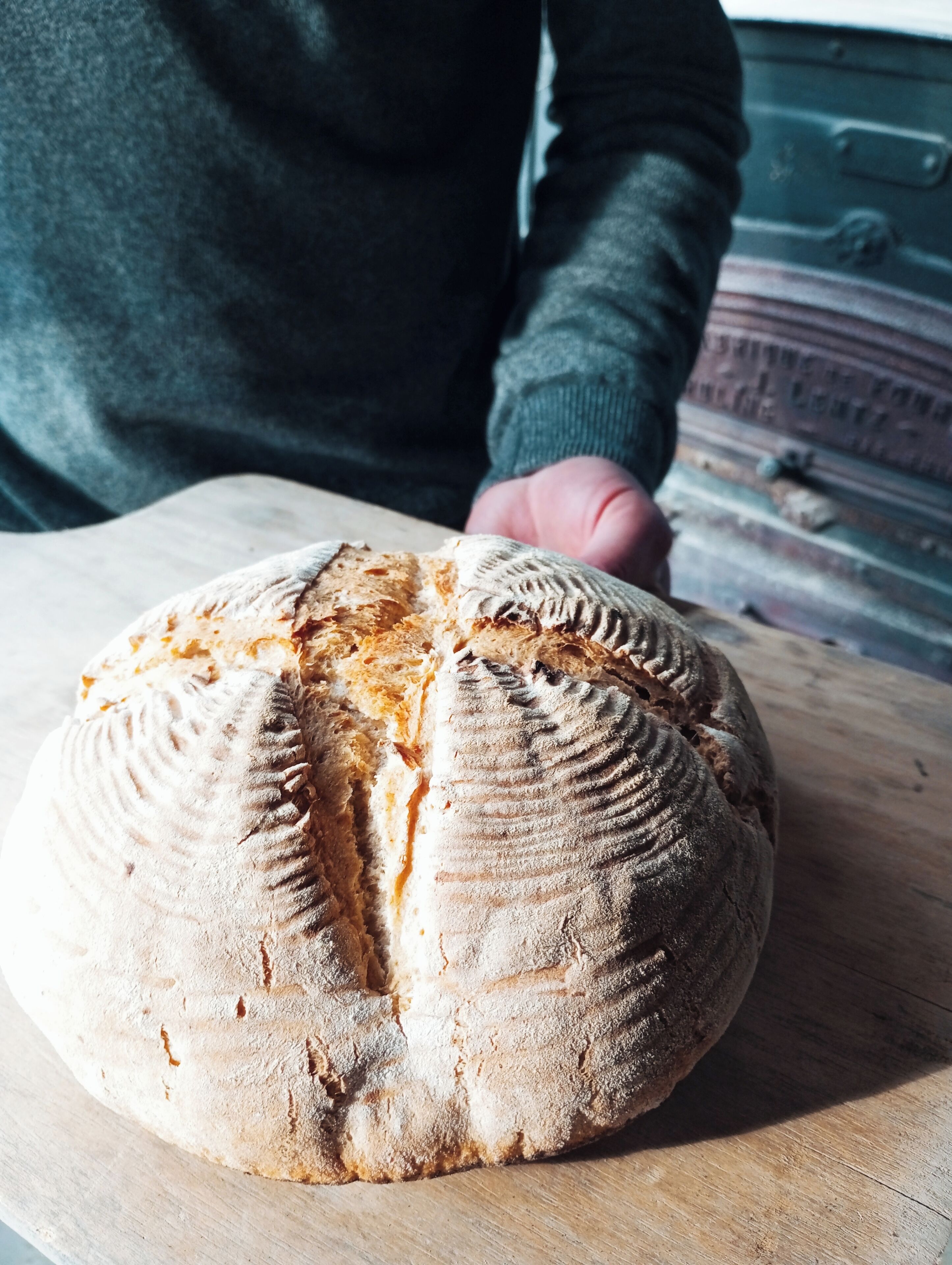 A loaf of bread on a wooden cutting board.
