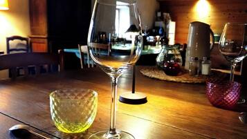 Une table à manger avec un verre à vin et un saladier en verre.