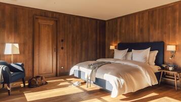A bedroom with a large bed, wooden walls, a chair, and a nightstand with a lamp.