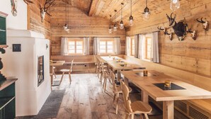 A rustic wooden interior with long tables and chairs, wooden ceiling beams, and mounted animal skulls. - Posthotel Taube (Schruns)