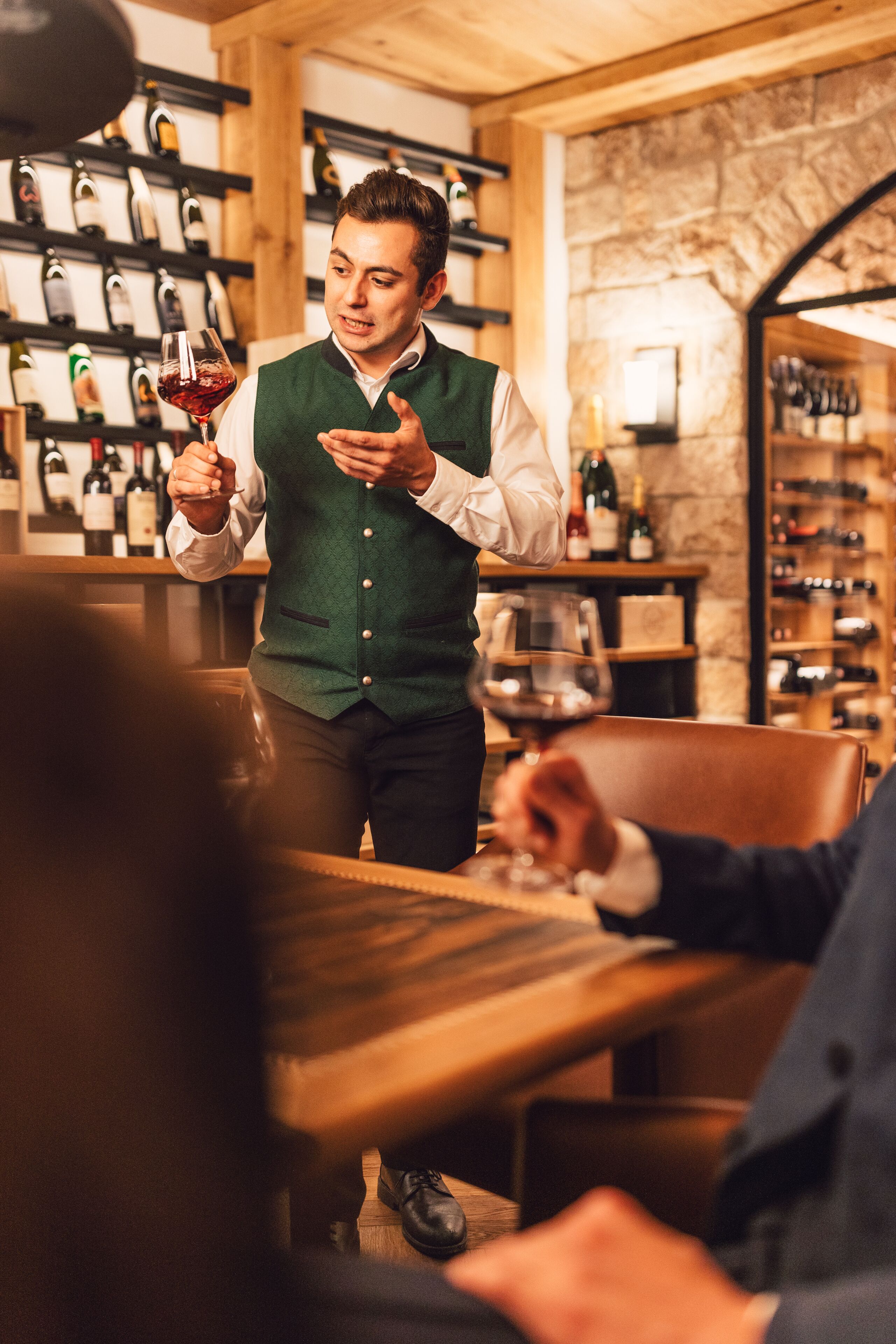A bar setting with a bartender serving a drink to a seated customer.