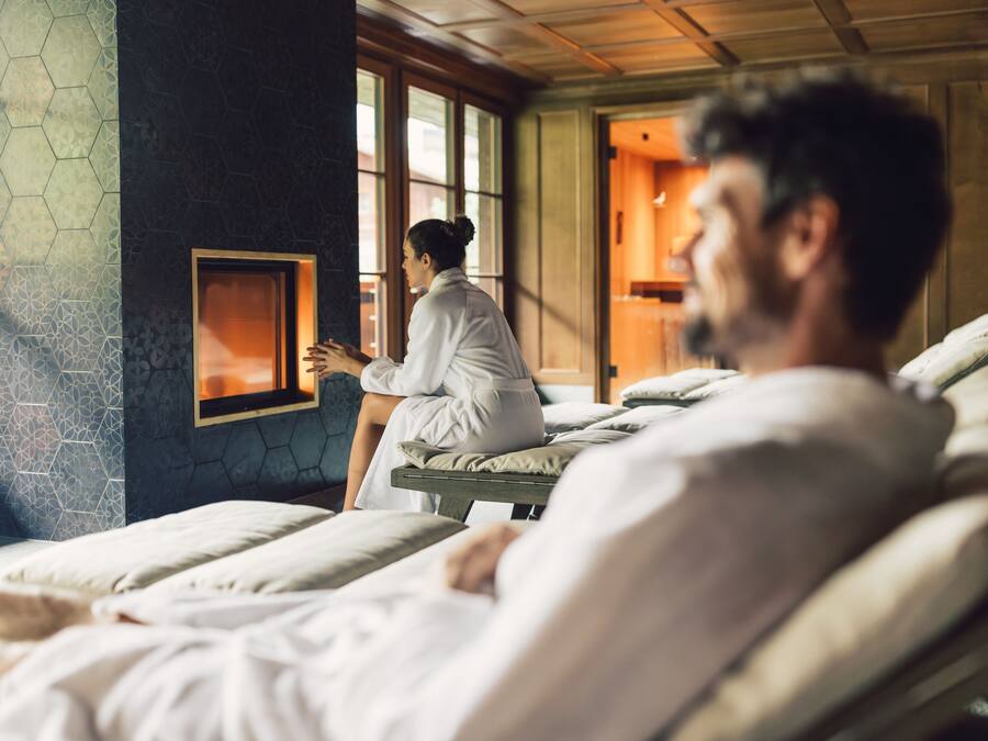 Una habitación con una mesa de masaje, un terapeuta de masajes y un cliente.