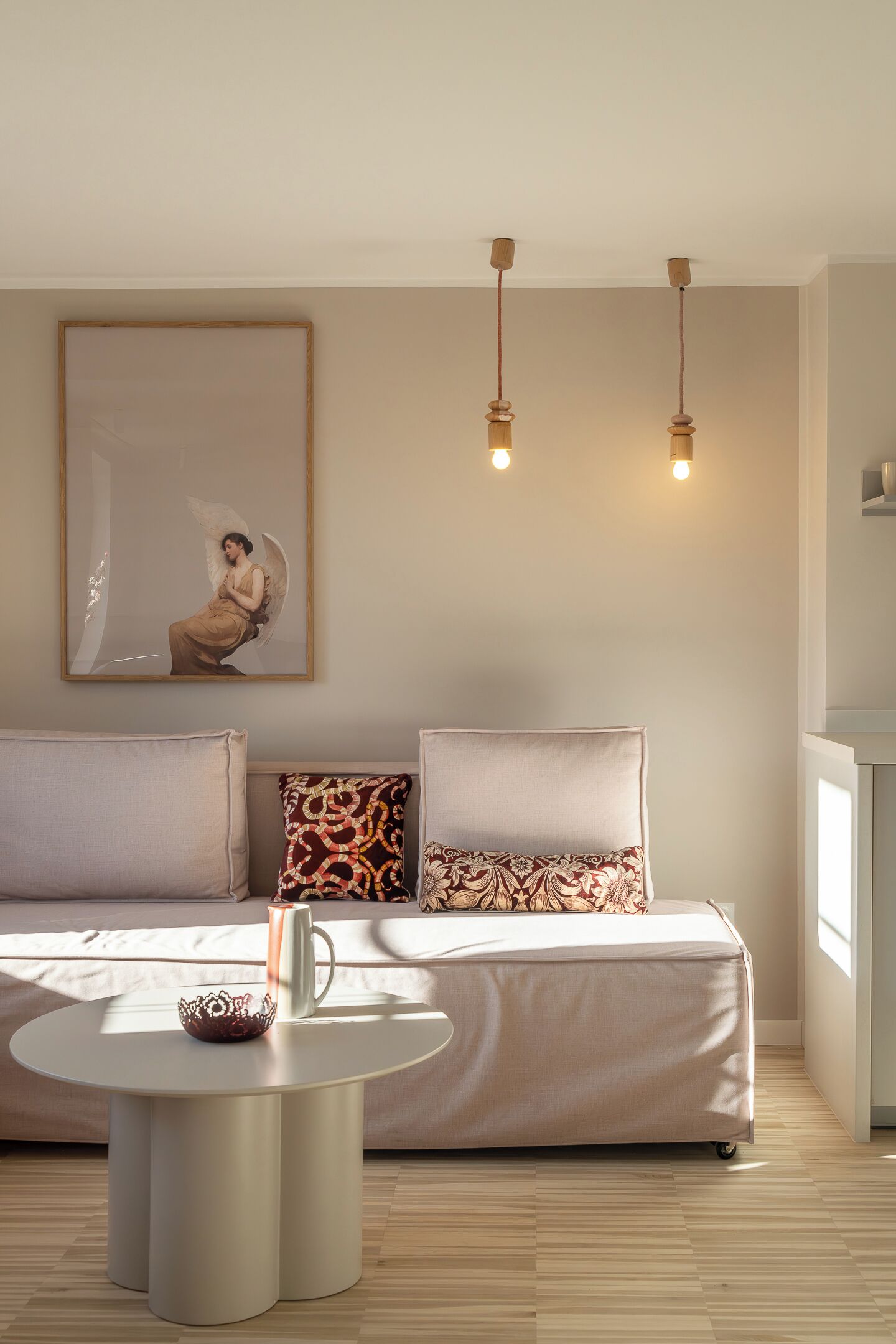 A modern living room with a sofa, two pillows, a coffee table, and a framed picture on the wall.